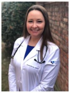 Smiling female doctor wearing a white coat.